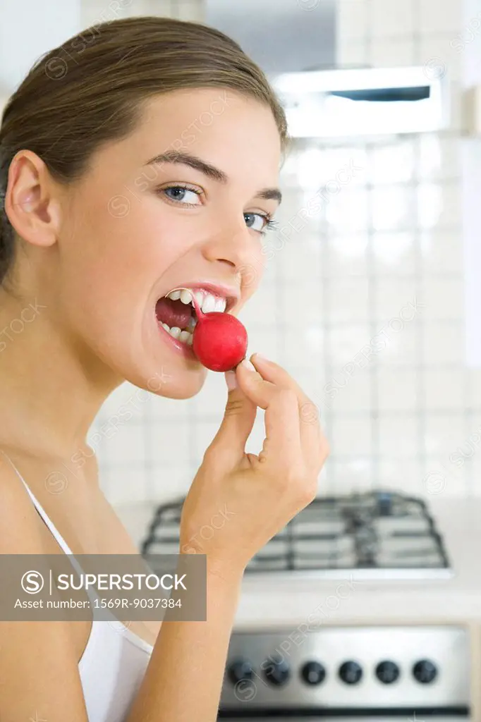 Woman biting into raw radish