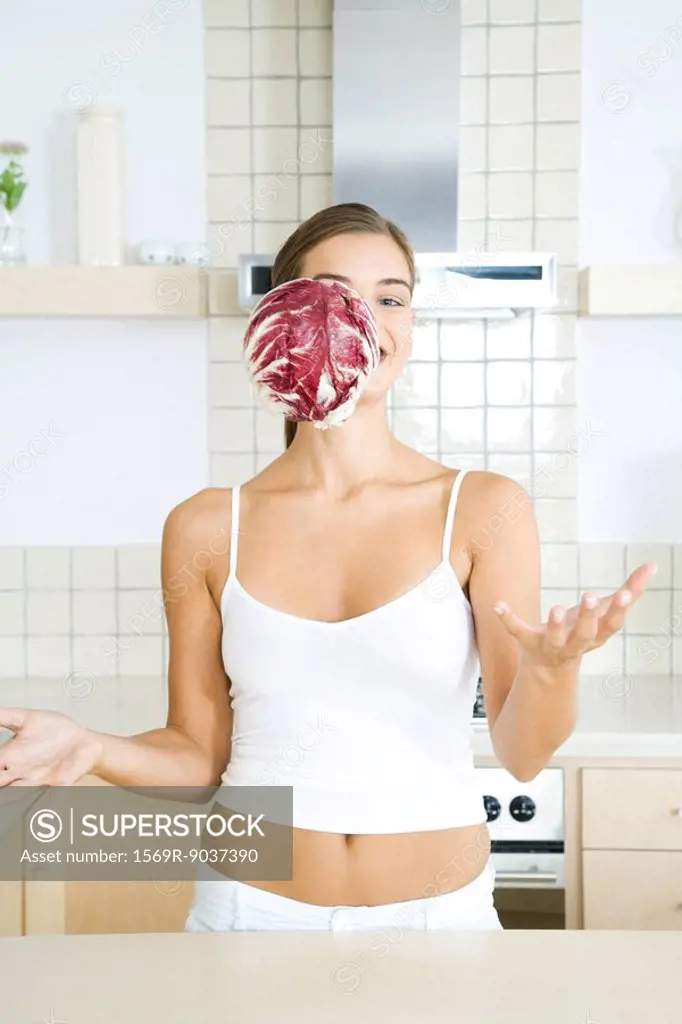 Woman with head of radicchio chicory falling in front of her face