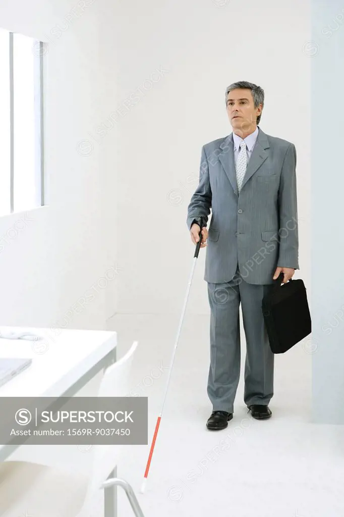 Blind businessman entering office, using white cane