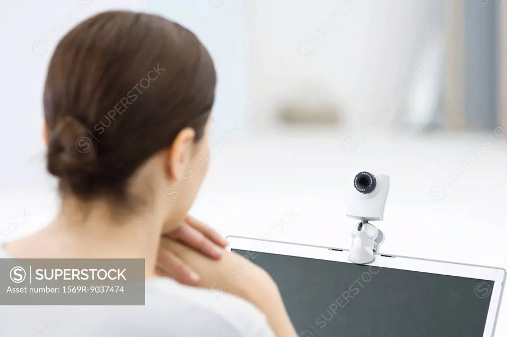 Woman looking at webcam, rear view
