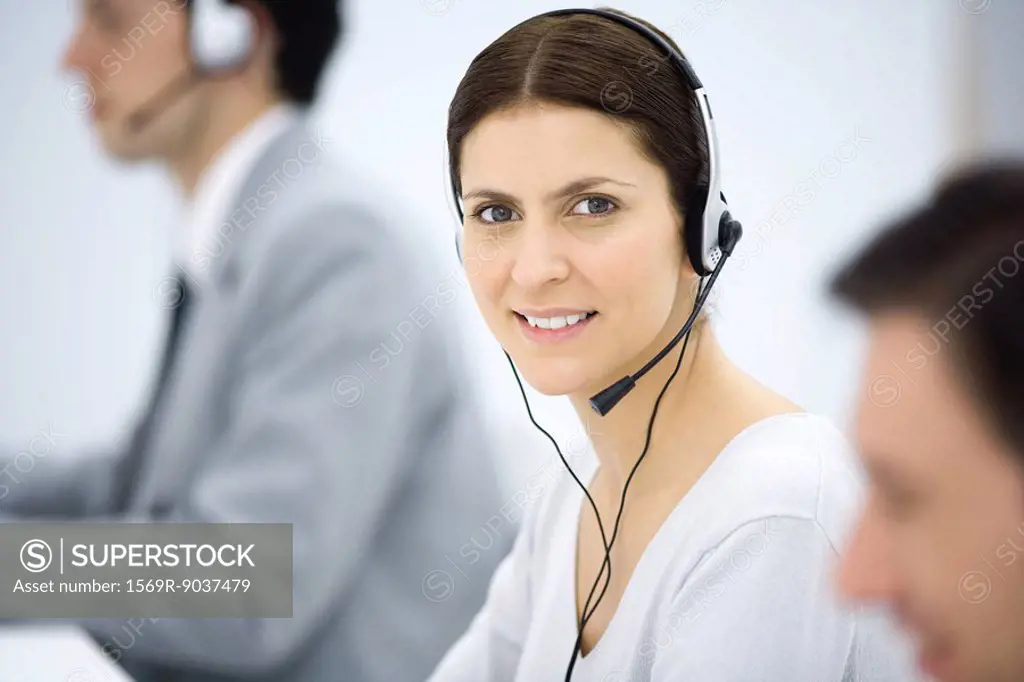 Female telemarketer smiling at camera, portrait