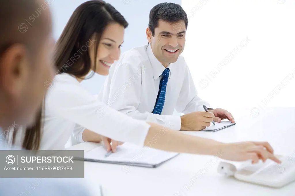 Professionals sitting at table, making conference call