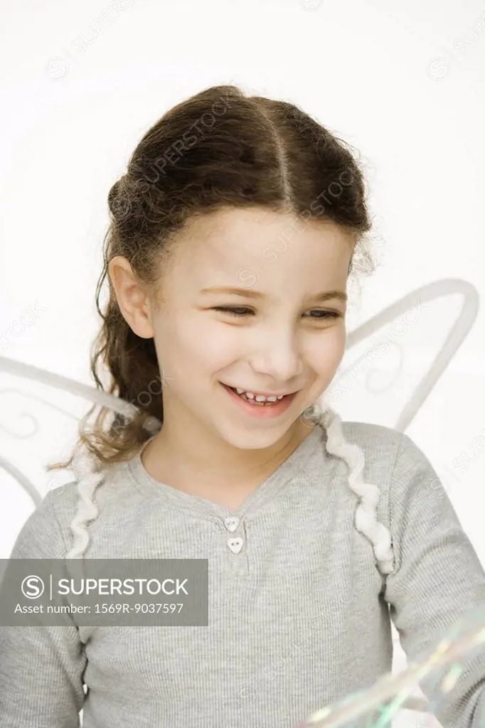 Little girl wearing wings, smiling, portrait