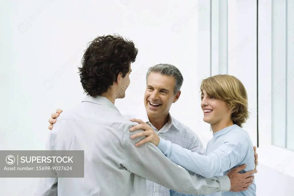 Father and two sons greeting each other, smiling