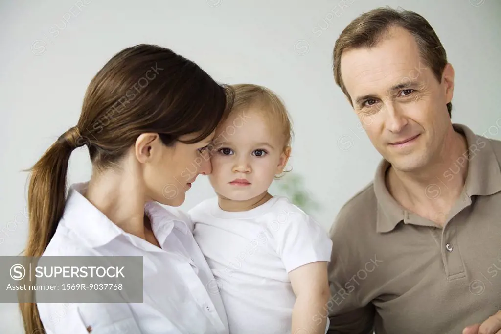 Man beside wife and toddler, smiling at camera