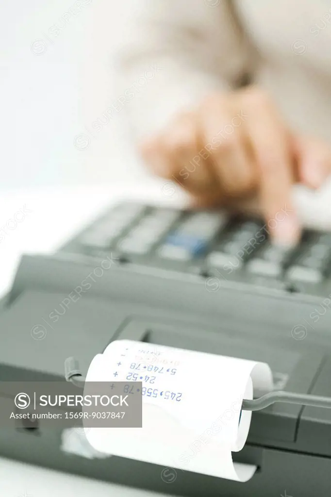 Person using adding machine, cropped view