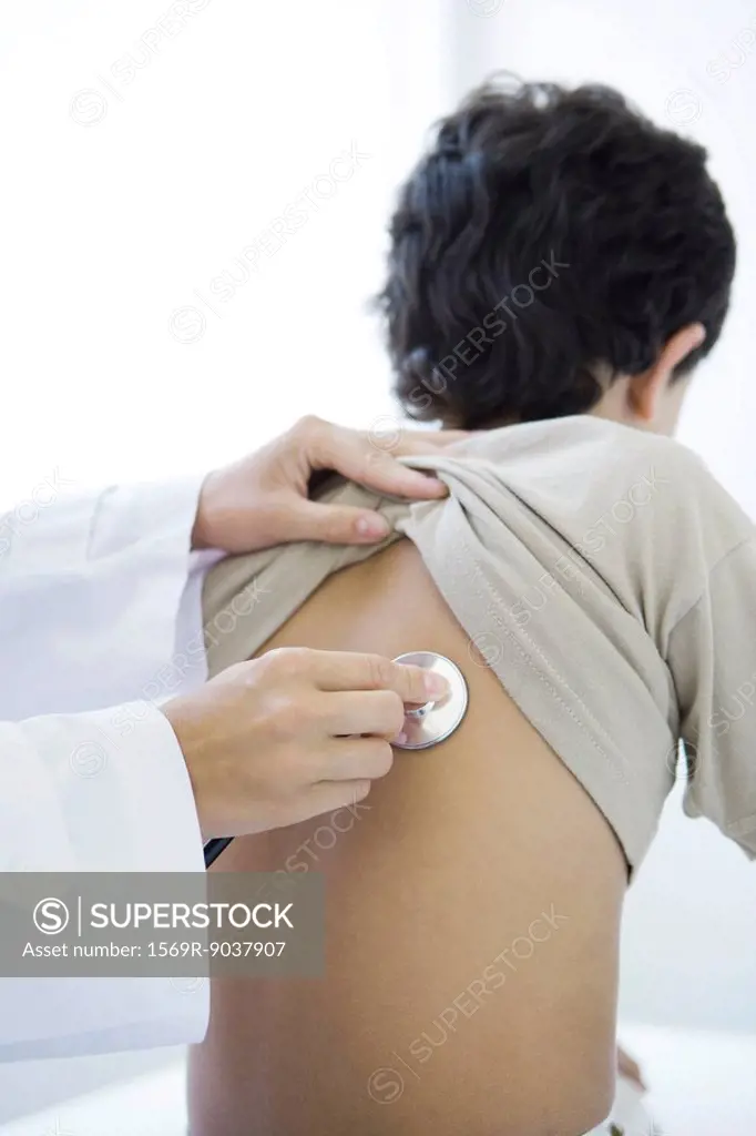 Doctor placing stethoscope on boy´s back, cropped view