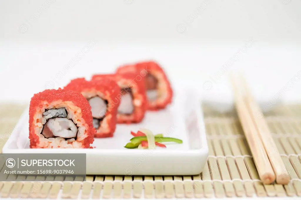 Maki sushi rolled in red flying fish roe, close-up