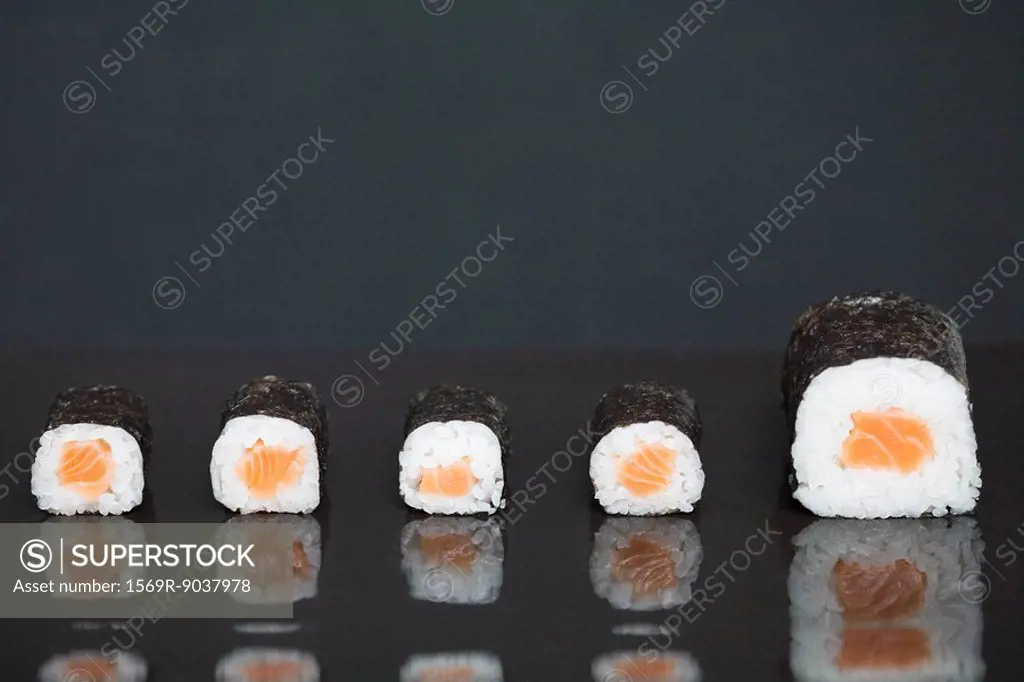 Maki sushi in a row, one piece larger than the others