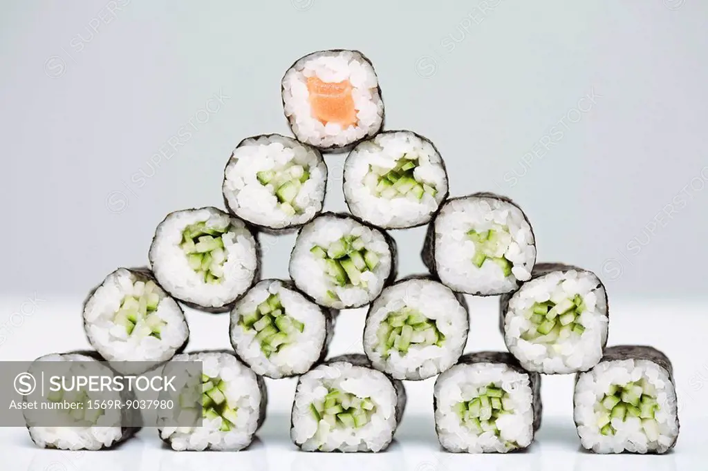 Group of maki sushi arranged in form of pyramid with single piece of salmon maki sushi at top