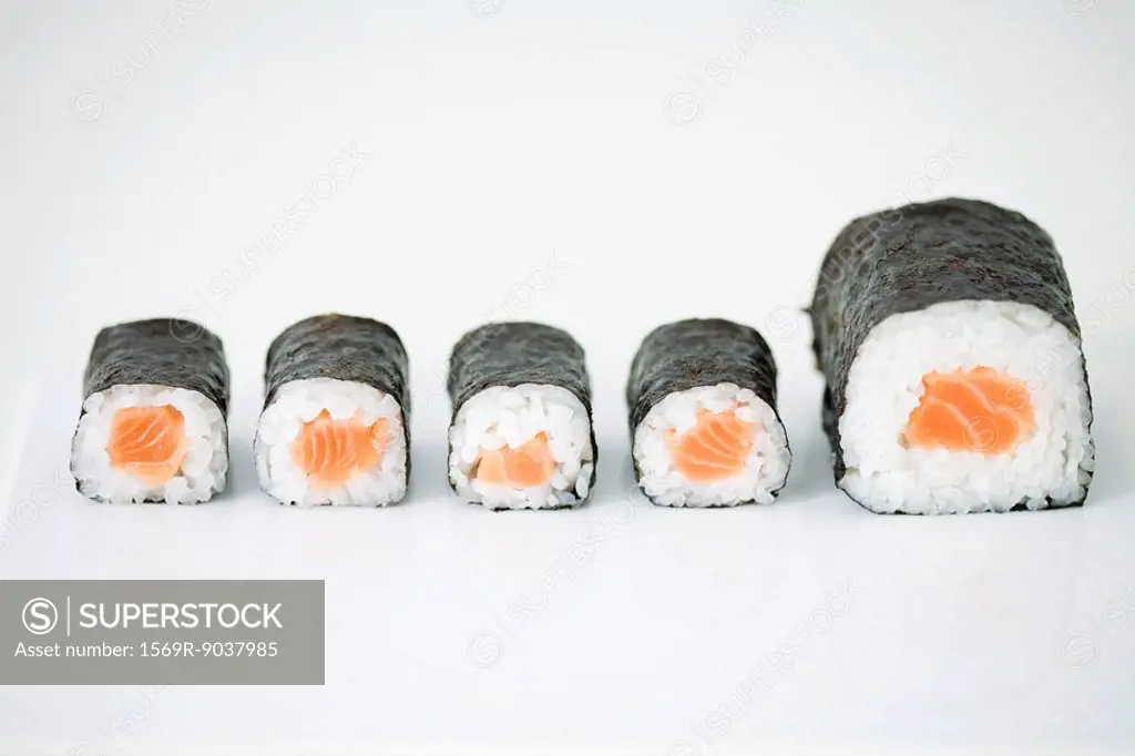 Five pieces of maki sushi arranged in row, end piece larger than others