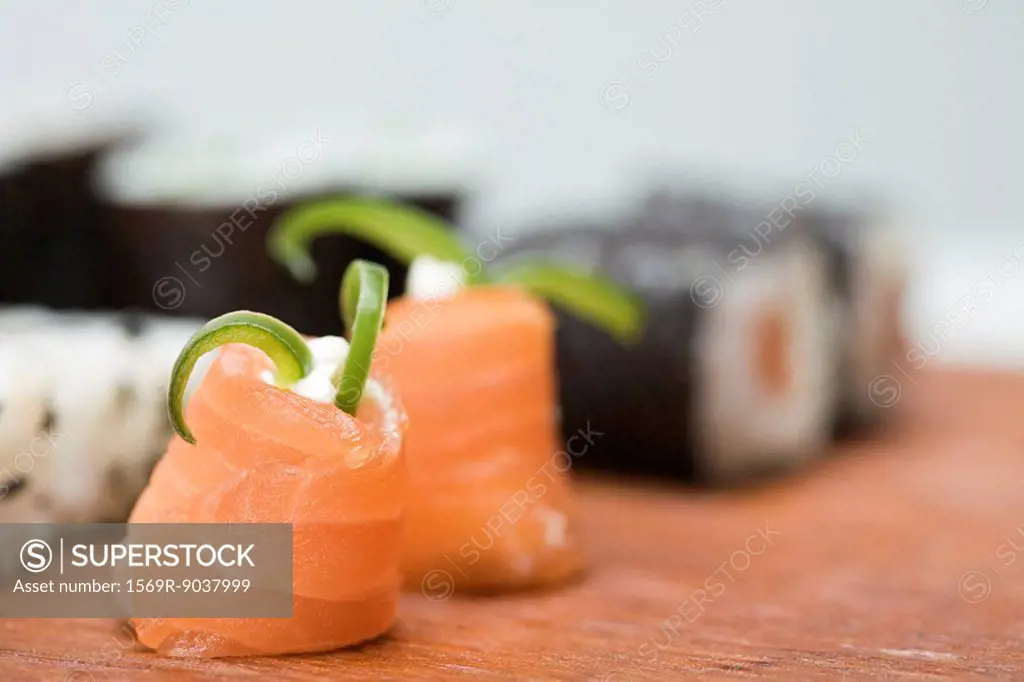 Cropped view of assorted maki sushi, focus on salmon in foreground
