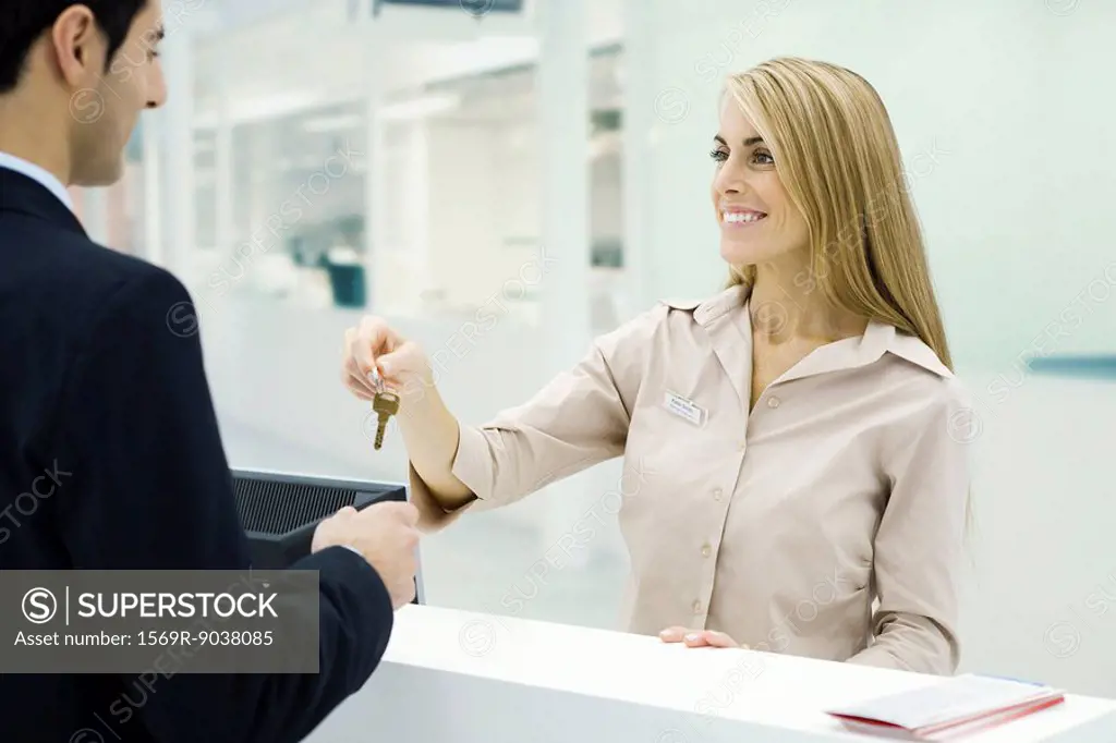 Customer service representative giving key to customer