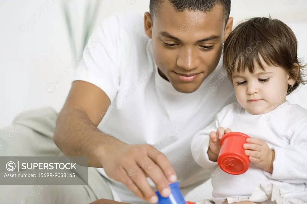 Father and toddler daughter playing with toys together