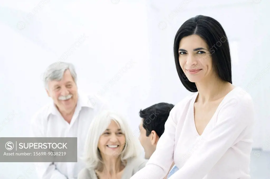 Woman smiling at camera, husband and parents in background