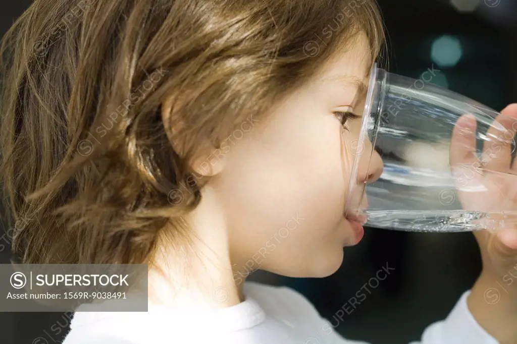 Little boy drinking water from glass, close-up