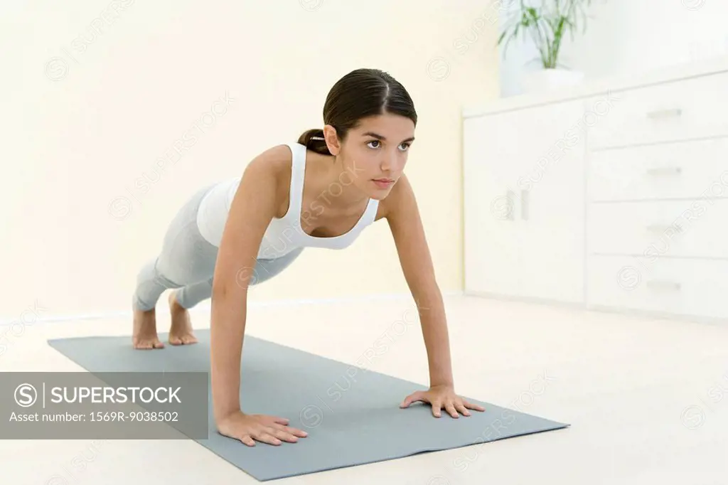 Woman doing push-ups on exercise mat