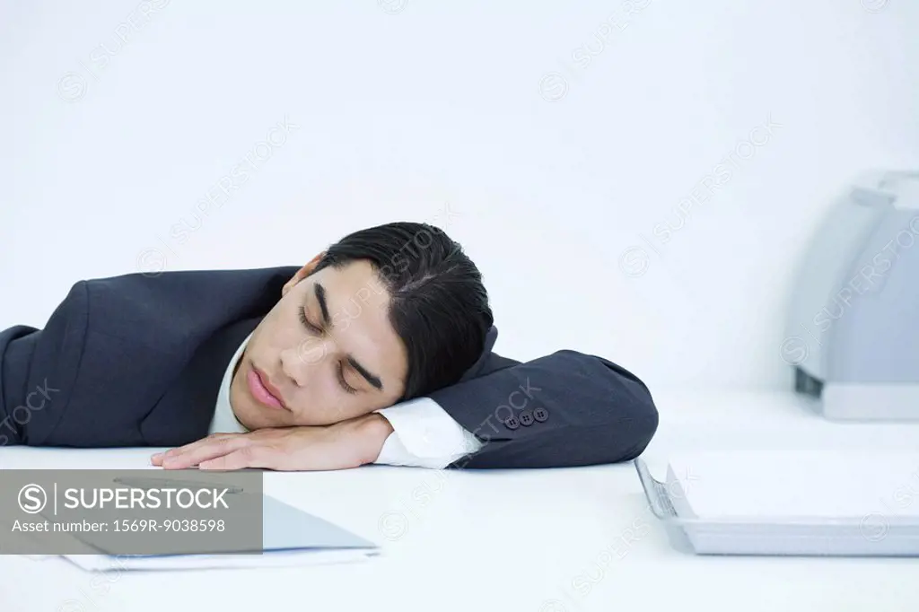 Young businessman napping at desk