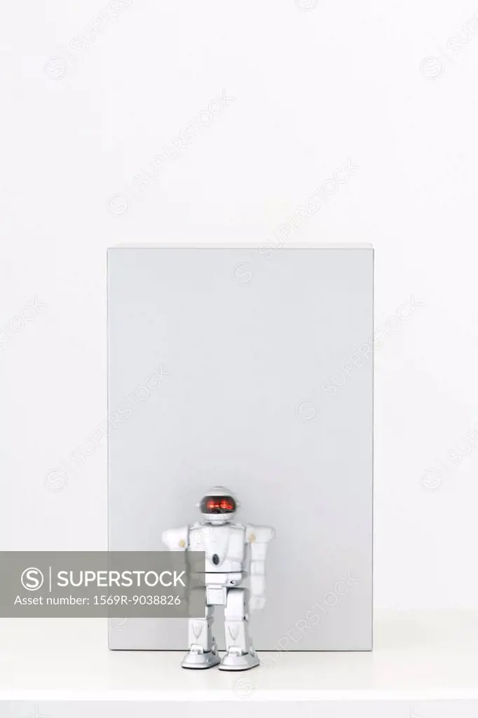 Toy robot in front of gray rectangle