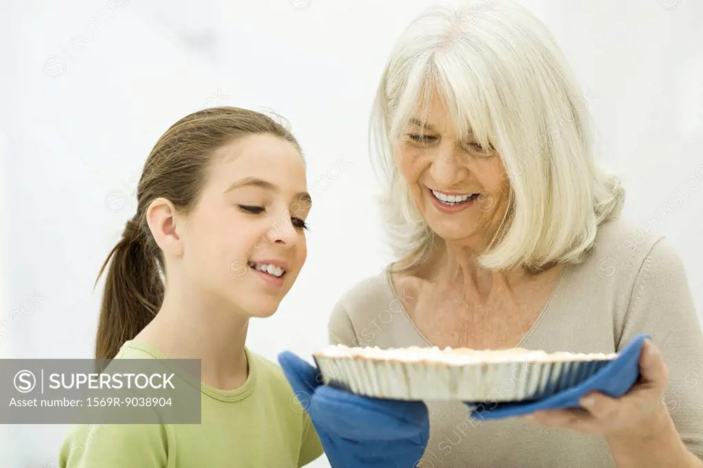 Grandmother and granddaughter looking down at freshly baked pie