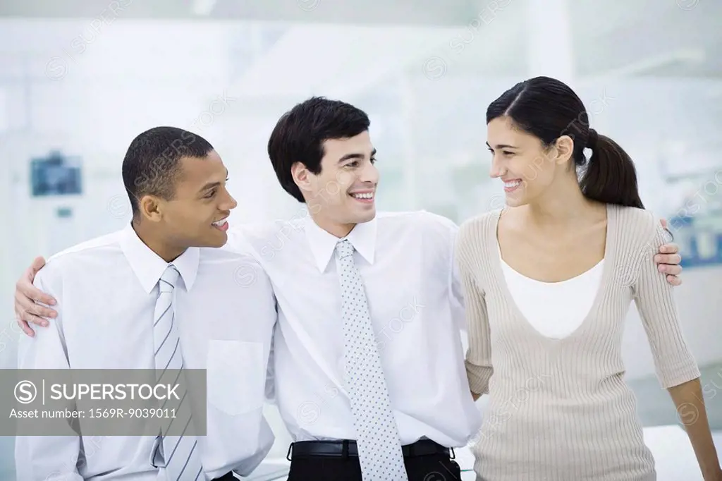 Three professionals with arms around each other´s shoulders, smiling, portrait