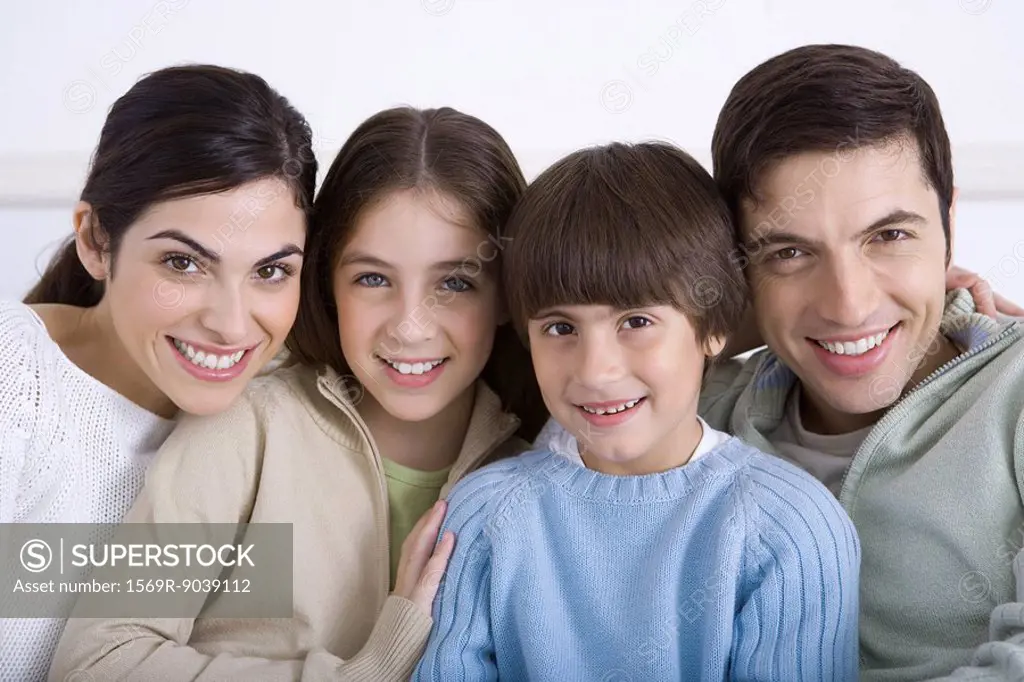 Family cheek to cheek, smiling at camera, portrait