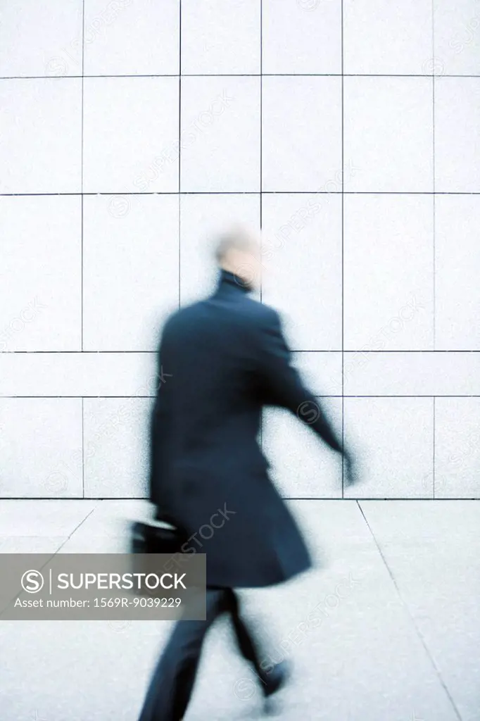 Businessman hurrying down sidewalk