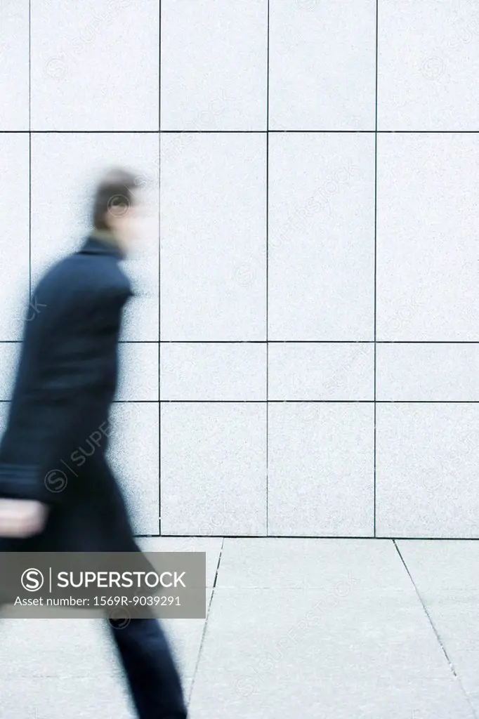 Businessman hurrying down sidewalk