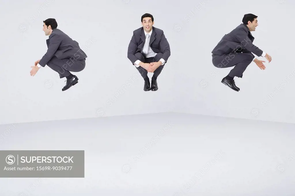 Identical businessmen jumping in midair