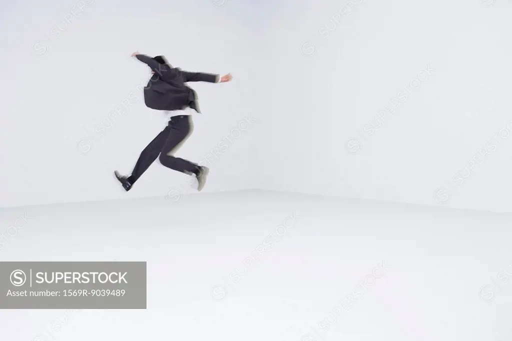 Businessman leaping, blurred motion