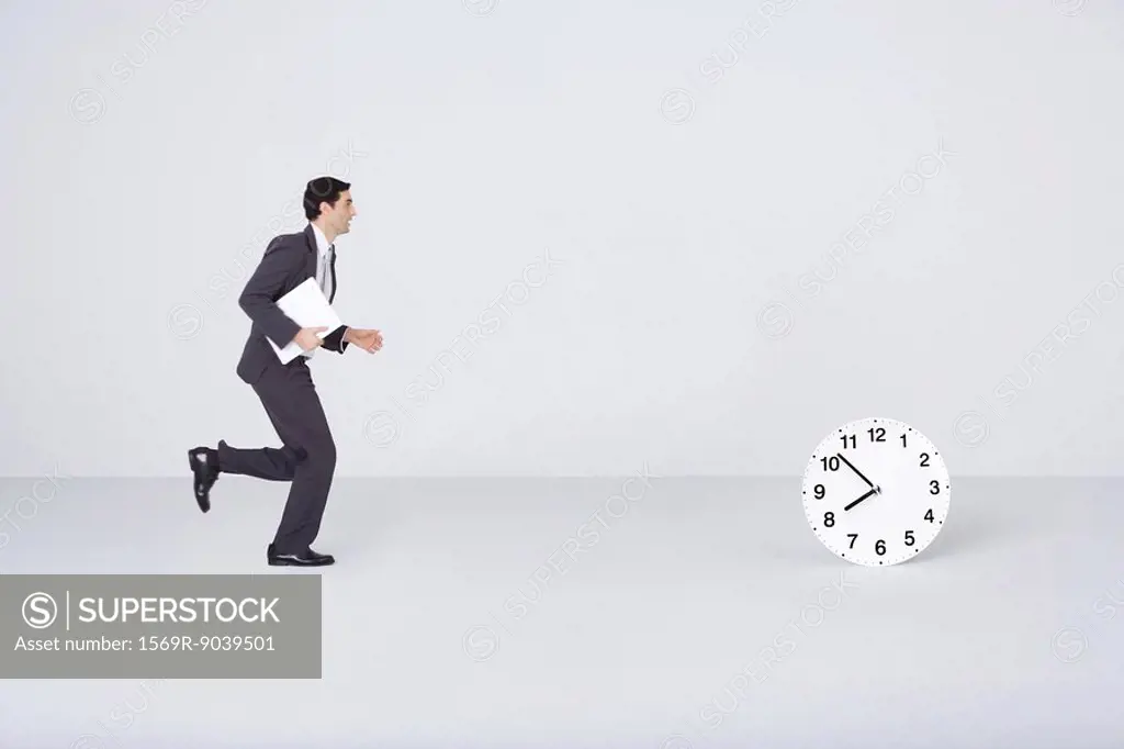 Businessman running toward clock