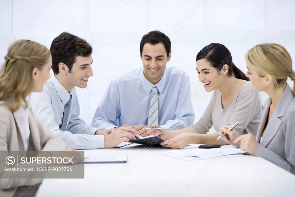 Group of professionals sitting at table, discussing document