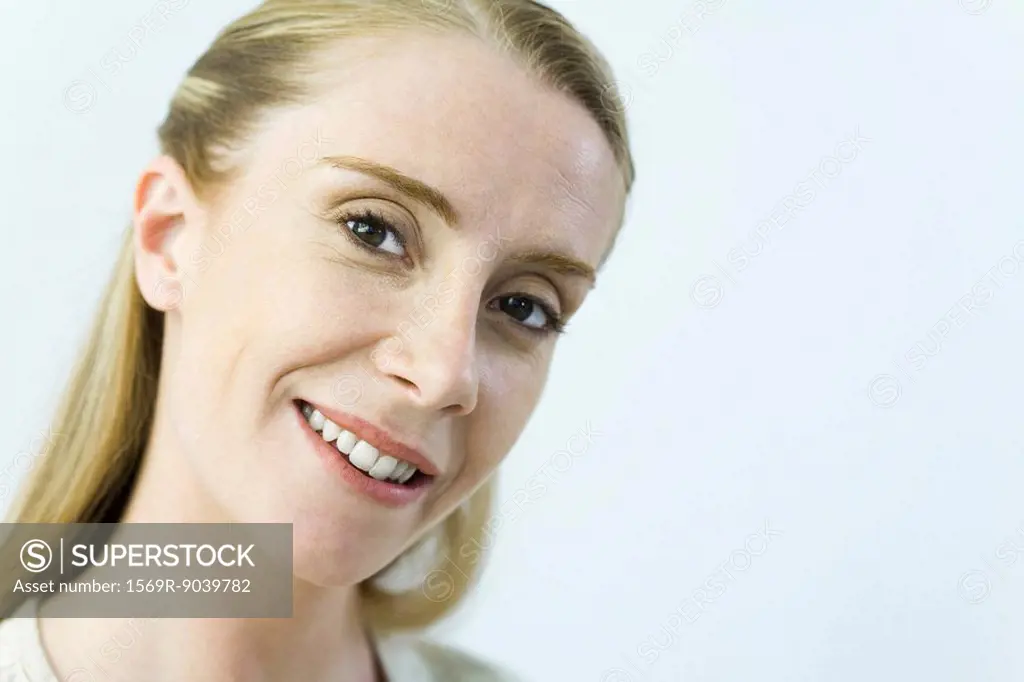Woman smiling at camera, head tilted, portrait