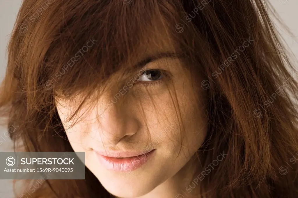 Young woman with tousled hair looking seductively at camera, portrait