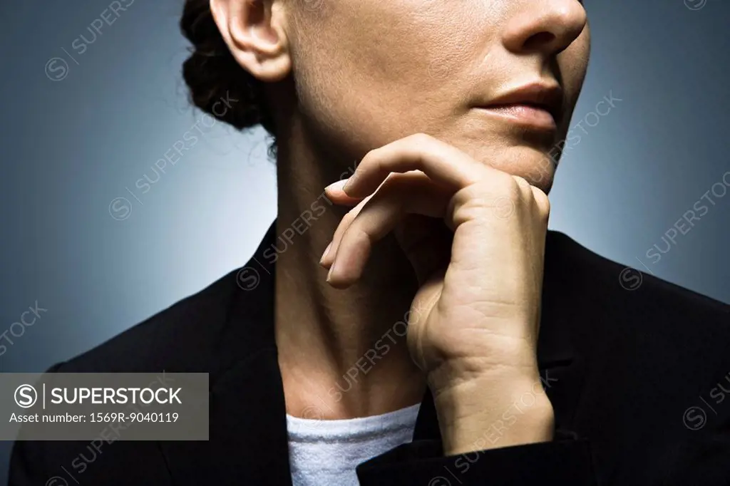 Woman with hand held under chin contemplatively looking away