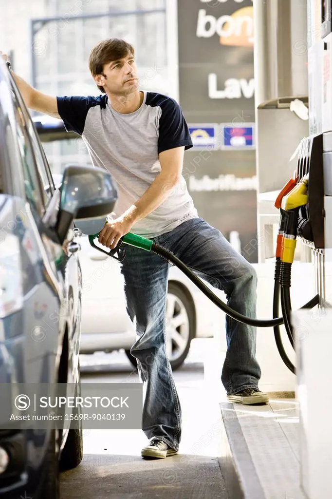 Man refueling vehicle at gas station