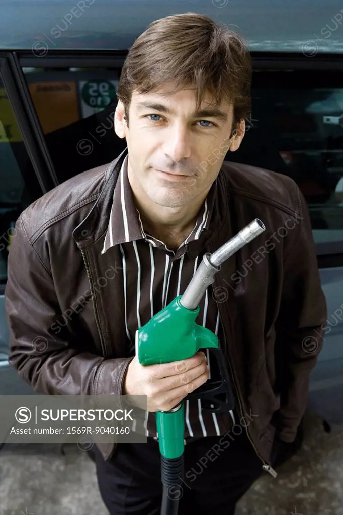Man at gas station holding gas nozzle