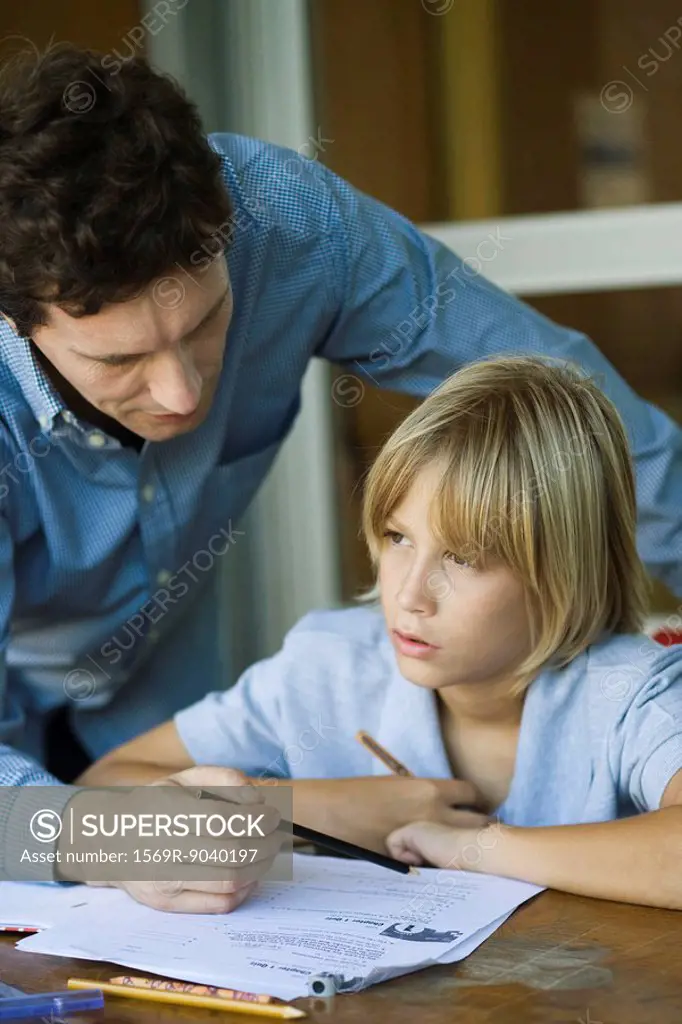 Male junior high student listening as teacher explains difficult assignment