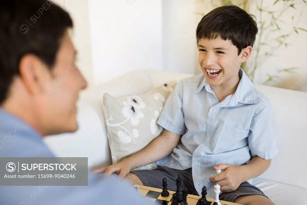 Father and young son playing chess