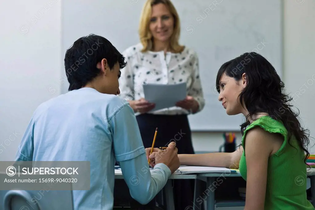 High school classmates helping each other in class