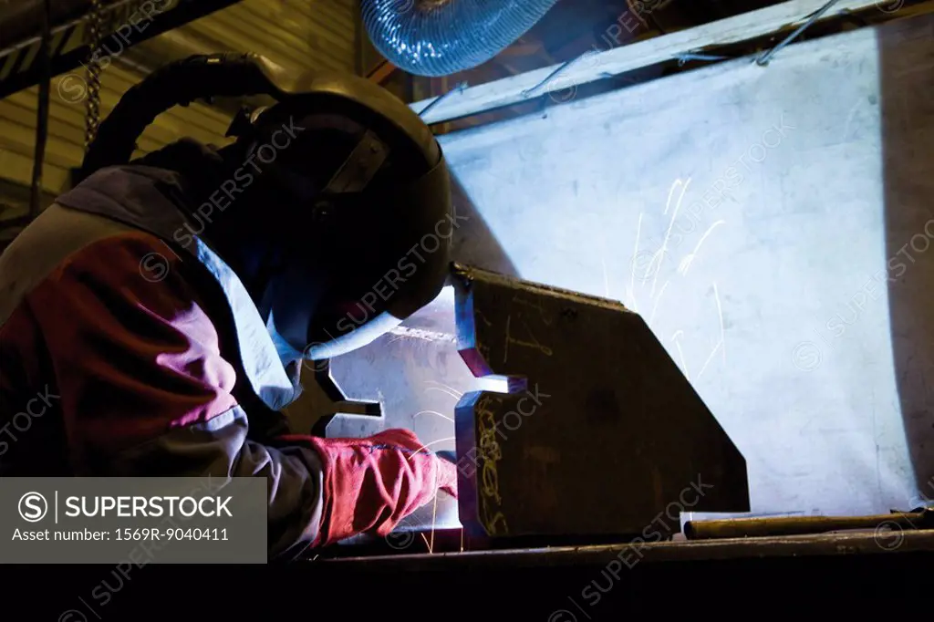 Coated textile plant, maintenance workshop, welder performing arc welding