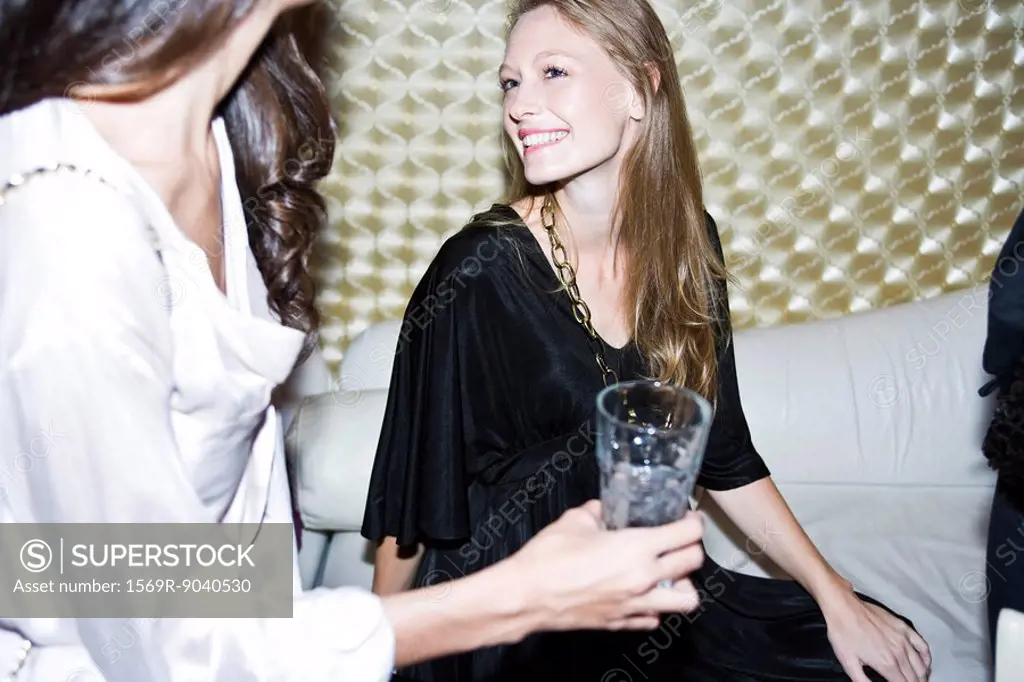 Young woman at night club chatting with friends