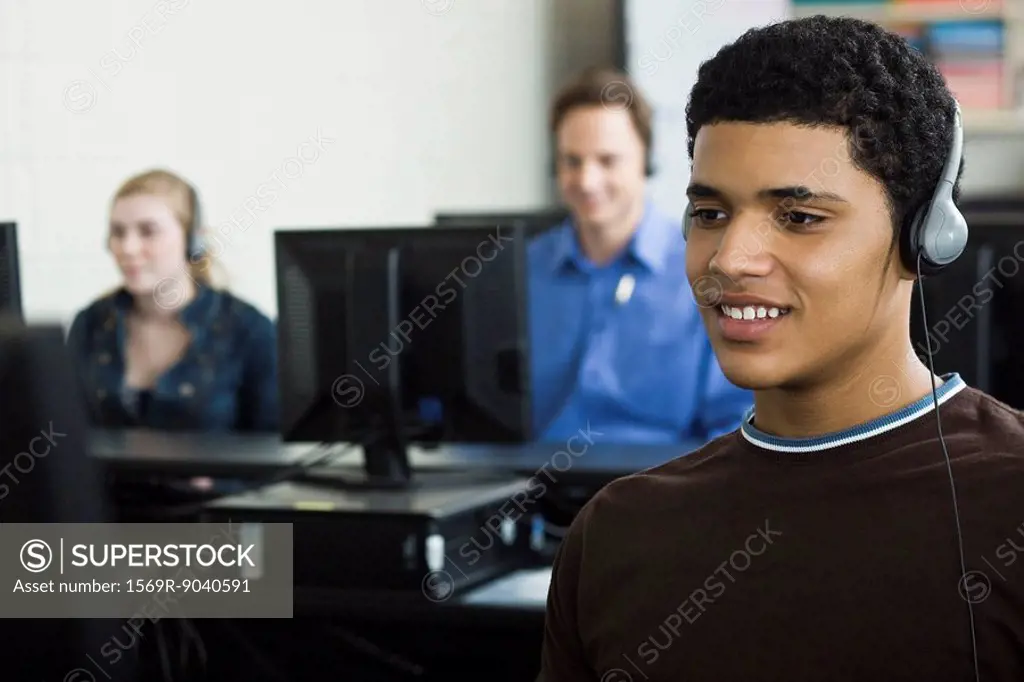Student listening to headphones in computer lab