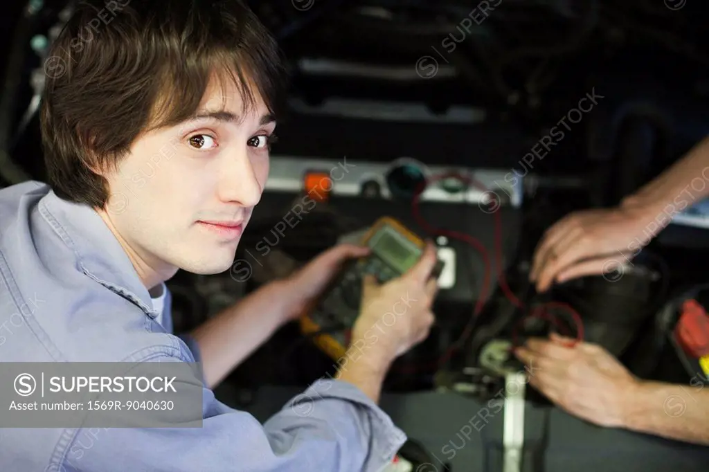 Mechanics repairing car engine