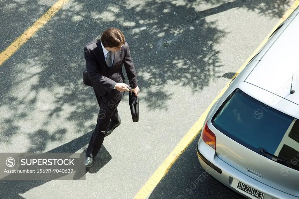 Man locking car doors using key remote as he walks away