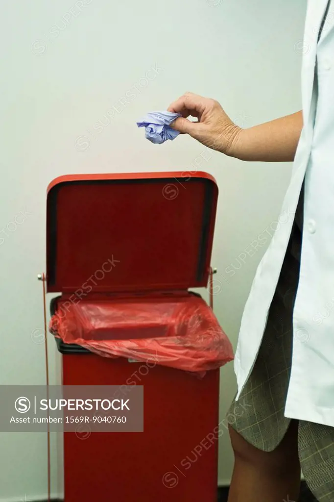 Discarding disposable latex glove in medical waste bin