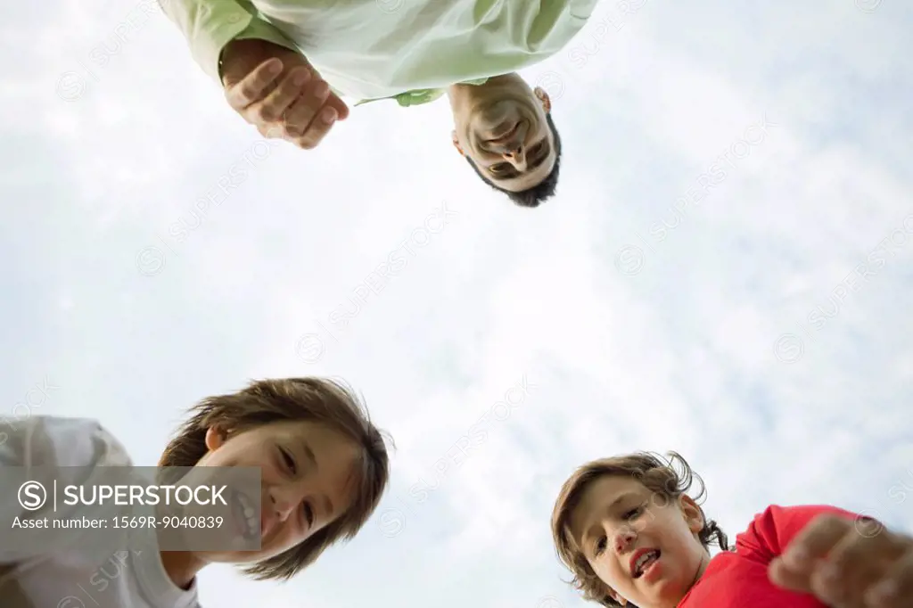Father and sons outdoors, low angle view