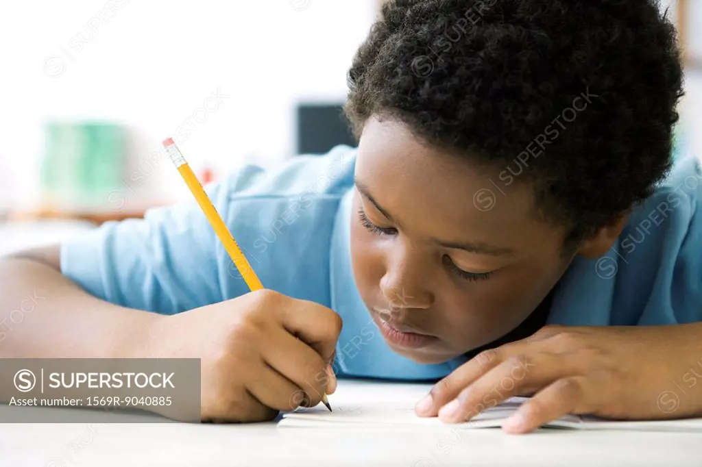 Male elementary school student concentrating on classwork