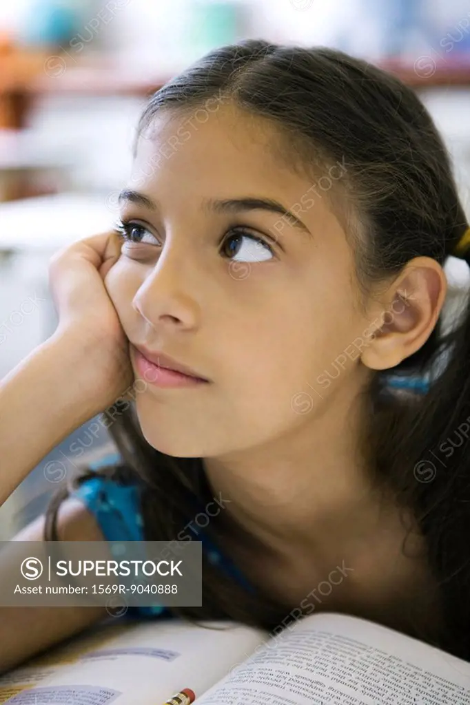 Female elementary school student daydreaming in class