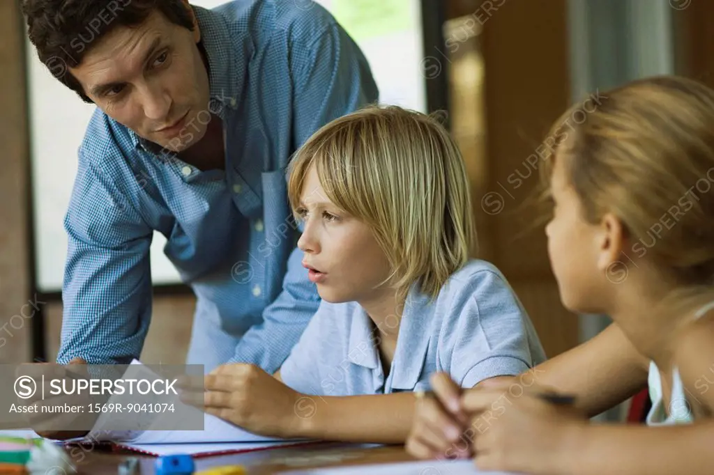 Teacher assisting students with their classwork assignments